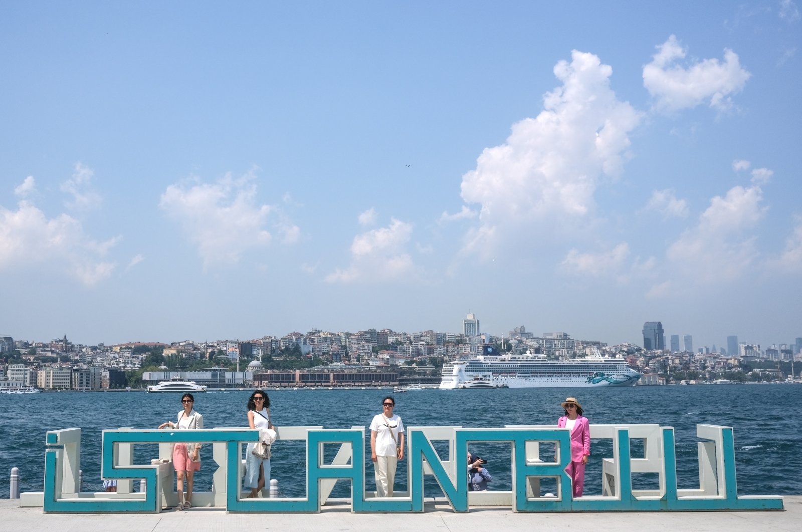 Tourists pose near the Bosporus on a hot summer day in Istanbul, Türkiye, July 11, 2023. (EPA Photo)