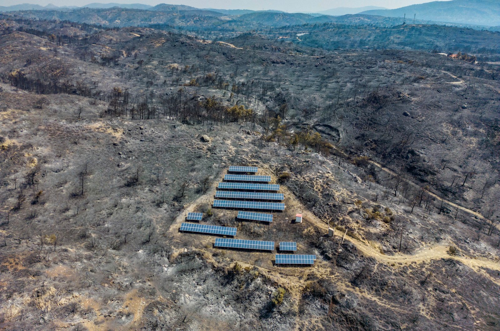 An aerial view of solar panels among charred trees, as a wildfire burns on the island of Rhodes, Greece July 27, 2023. (Reuters Photo)