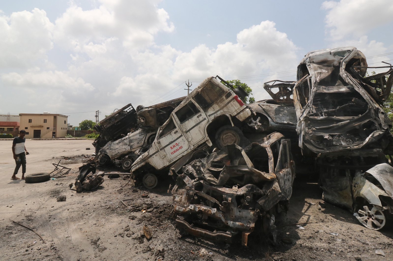 A man stands next to burnt vehicles dumped near a bus stand in the aftermath of riots in Nuh, Haryana state, India, Aug. 1, 2023. (EPA Photo)
